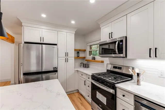 a kitchen with stainless steel appliances a refrigerator stove and microwave