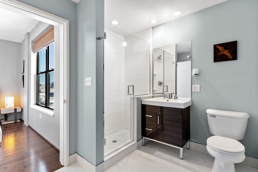 345 D Street, Unit 11 Boston, MA 02127 - Photo 15 of 23 a bathroom with a toilet sink and mirror