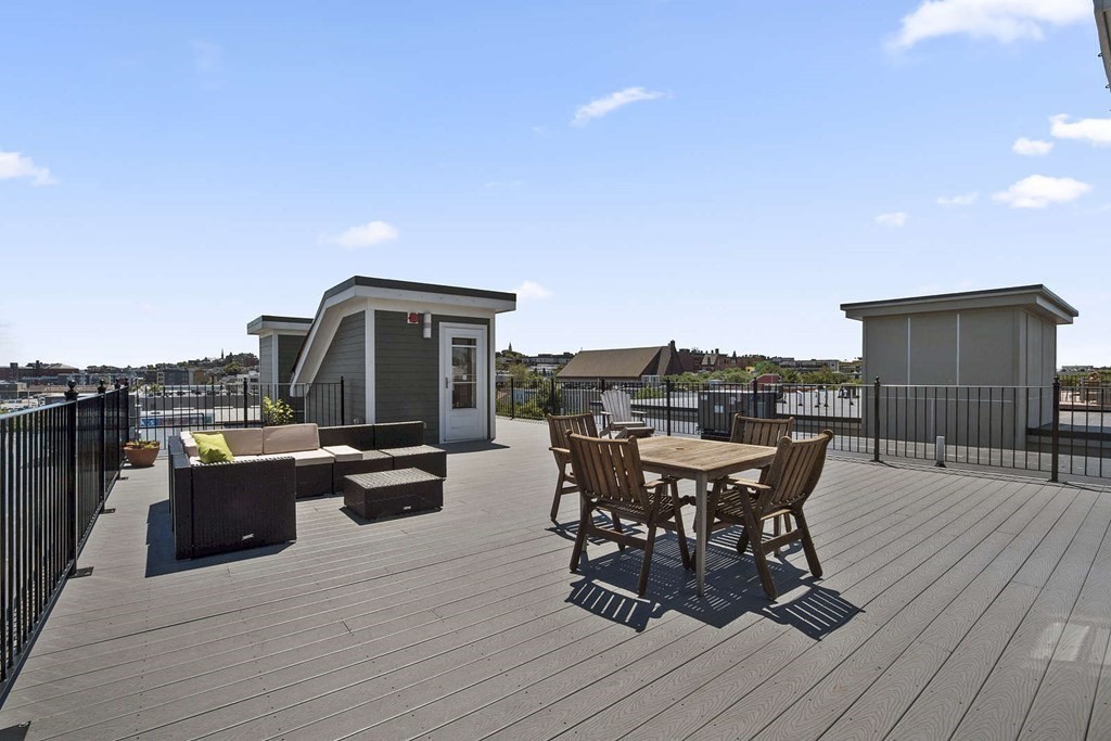 345 D Street, Unit 11 Boston, MA 02127 - Photo 20 of 23 a view of a roof deck with table and chairs couches with wooden floor and fence