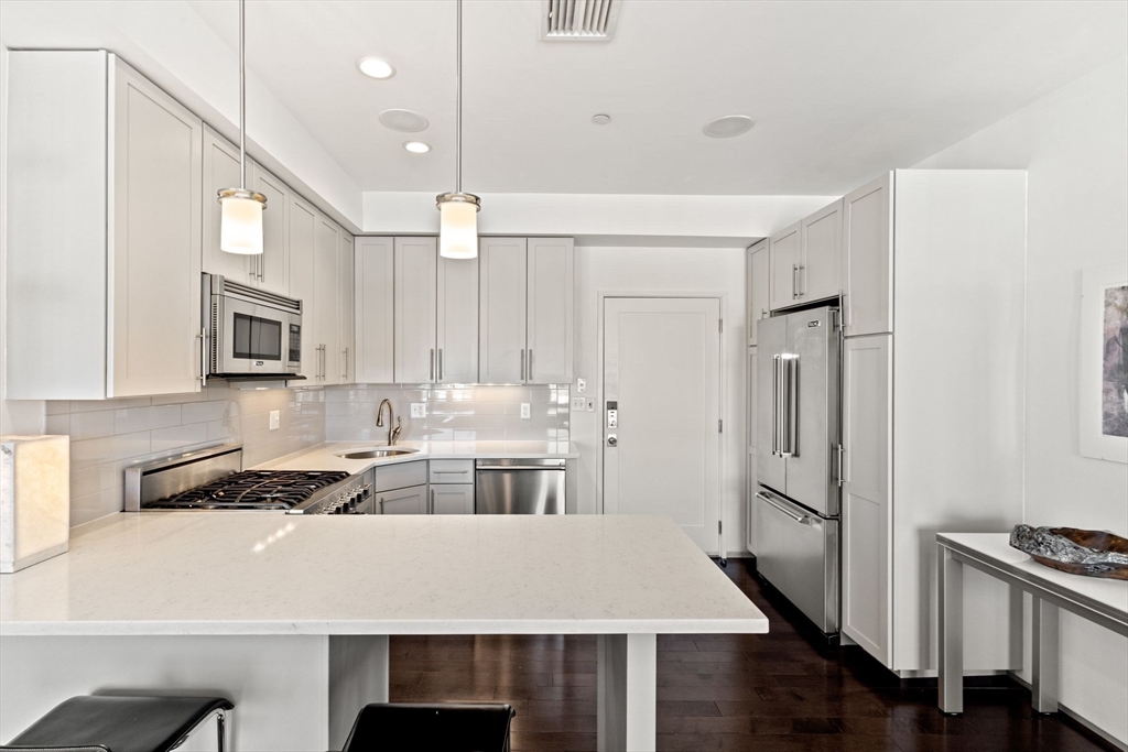 345 D Street, Unit 11 Boston, MA 02127 - Photo 9 of 23 a kitchen with a refrigerator a sink and cabinets