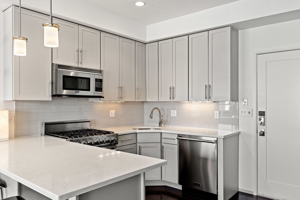 345 D Street, Unit 11 Boston, MA 02127 - Photo 10 of 23 a kitchen with a sink a stove and cabinets