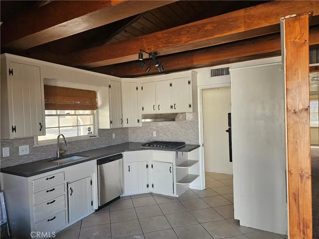 a kitchen with granite countertop white cabinets white appliances with a sink and dishwasher