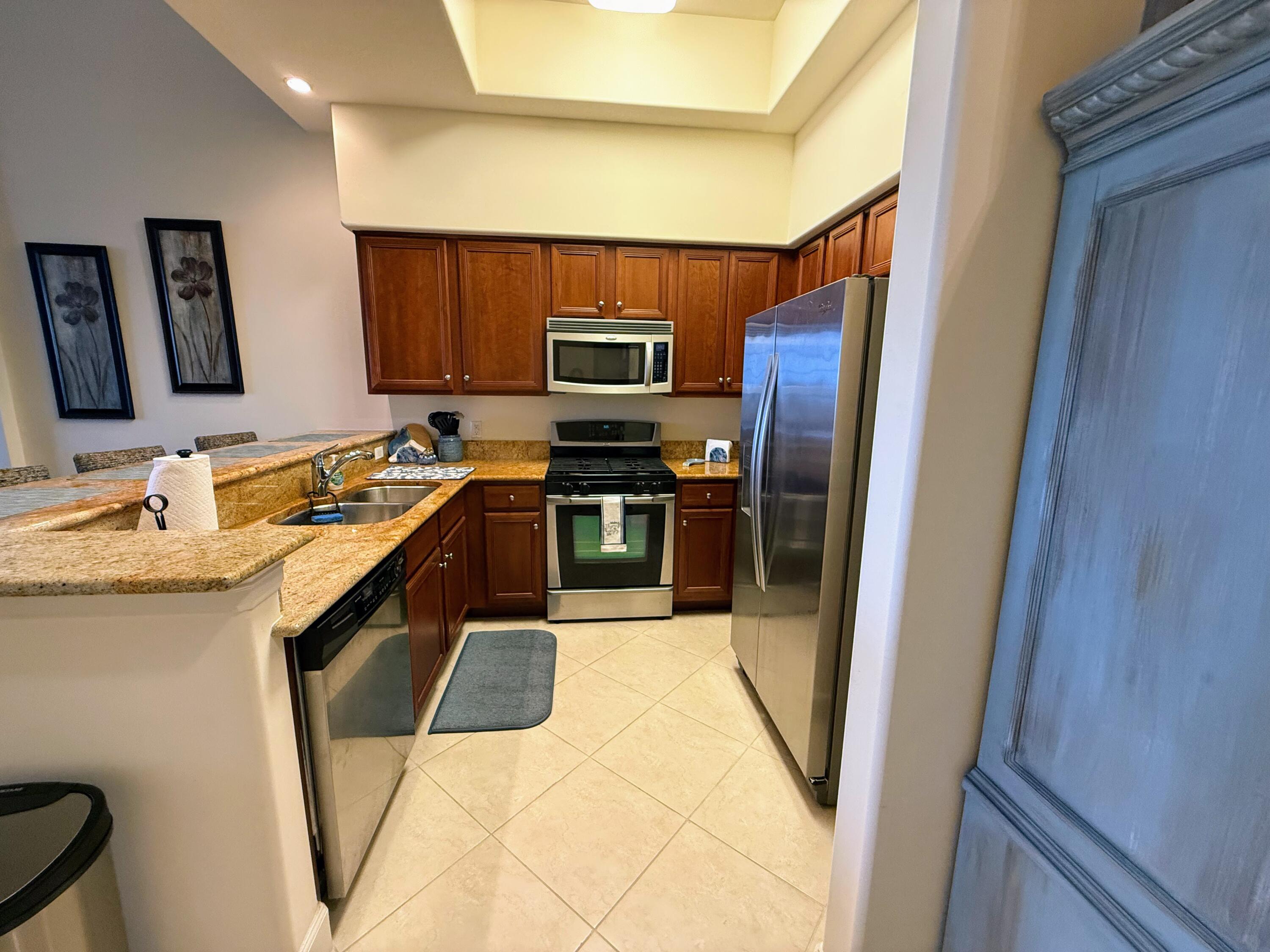 20 Orange Avenue, Unit 9 Fort Pierce, FL 34950 - Photo 57 of 92 a kitchen with stainless steel appliances granite countertop a sink and a refrigerator