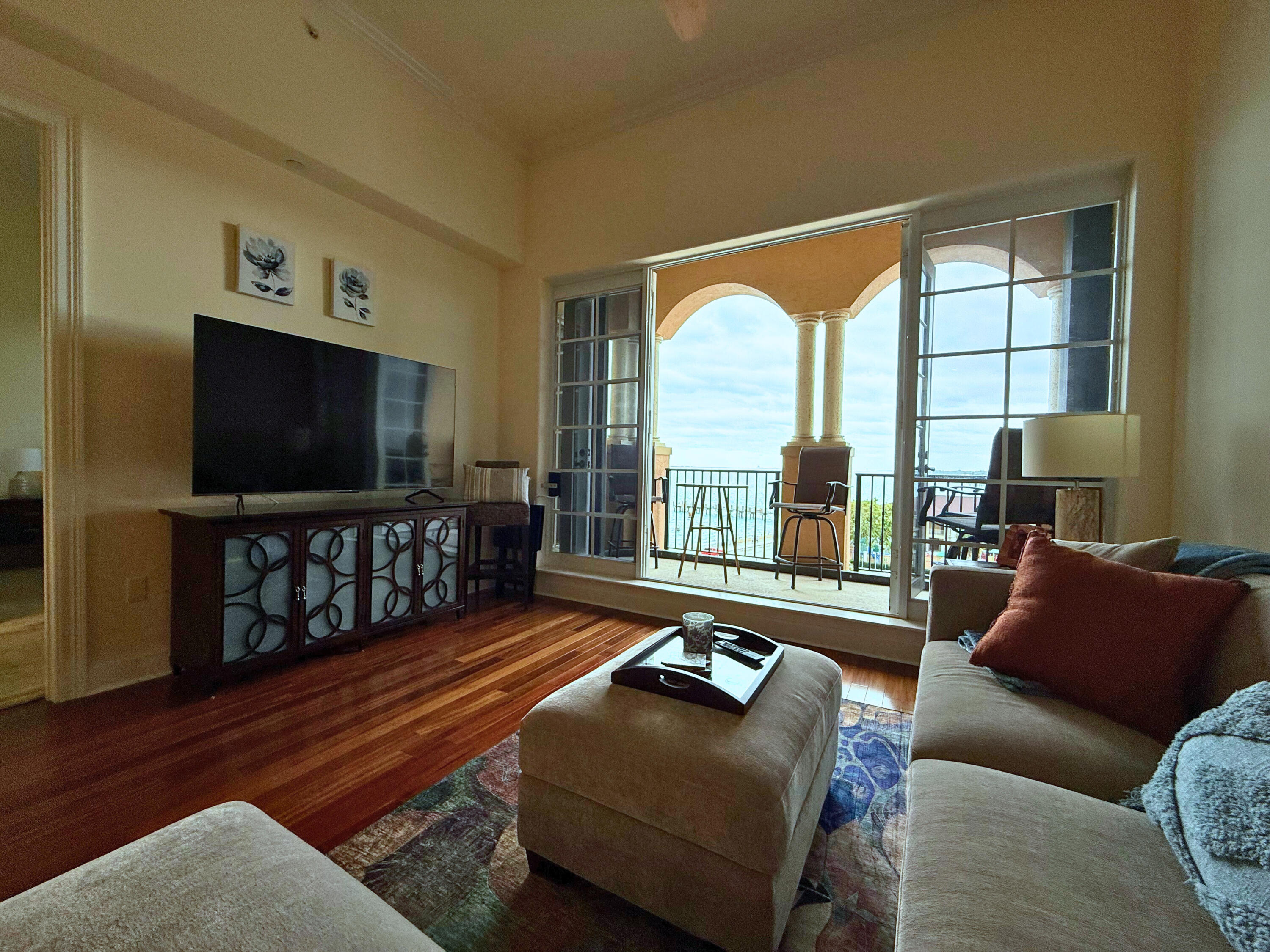 20 Orange Avenue, Unit 9 Fort Pierce, FL 34950 - Photo 61 of 92 a living room with furniture a flat screen tv and a floor to ceiling window