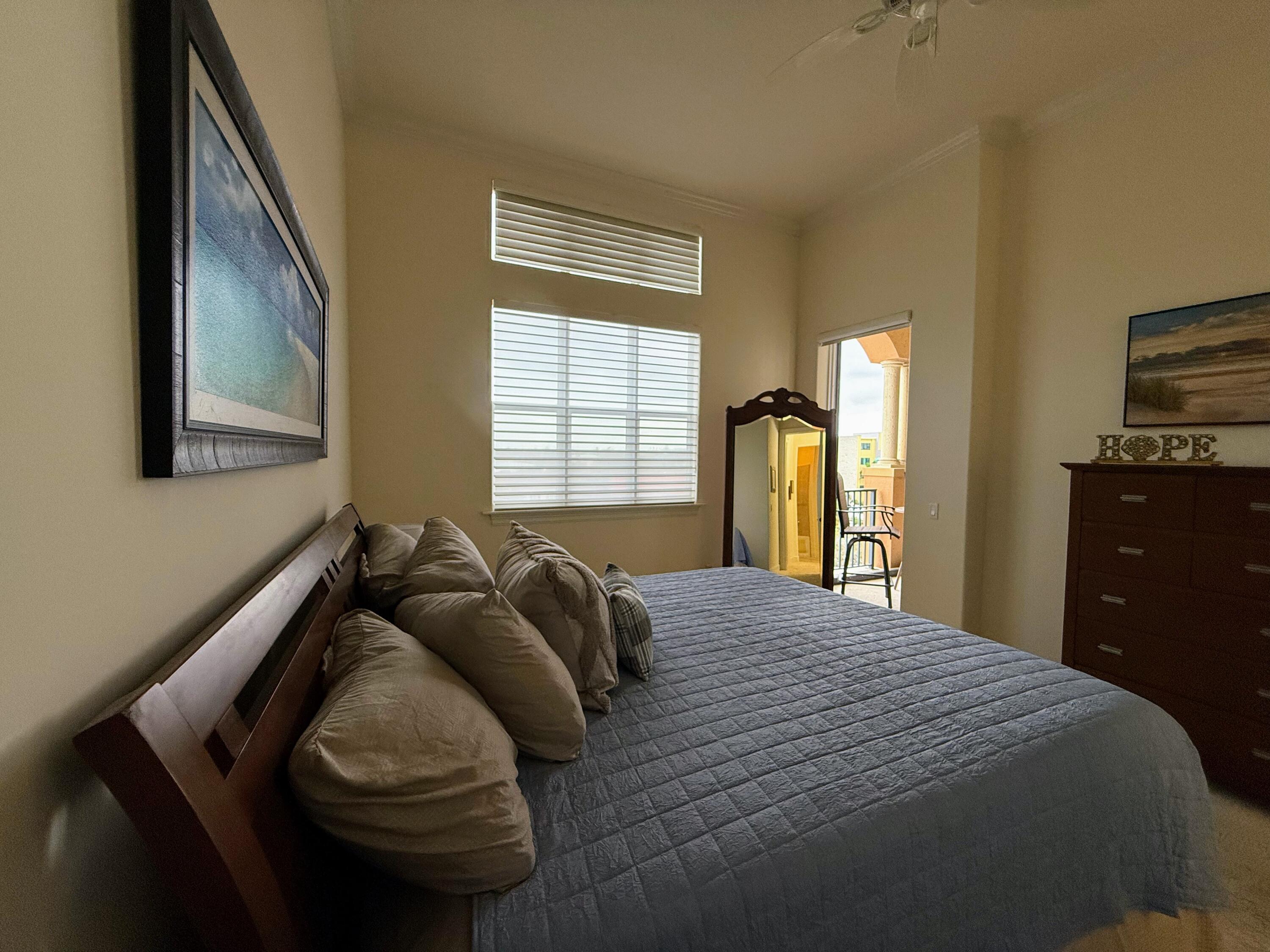 20 Orange Avenue, Unit 9 Fort Pierce, FL 34950 - Photo 67 of 92 a bedroom with a bed and dresser with mirror