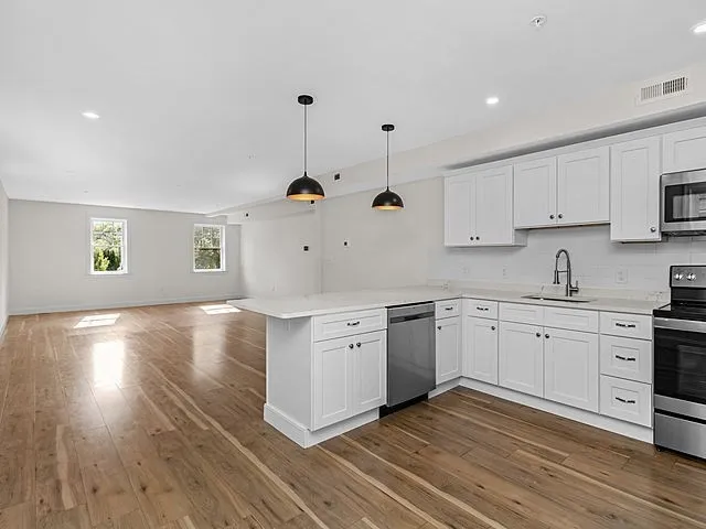 a kitchen with stainless steel appliances granite countertop a sink a stove and cabinets