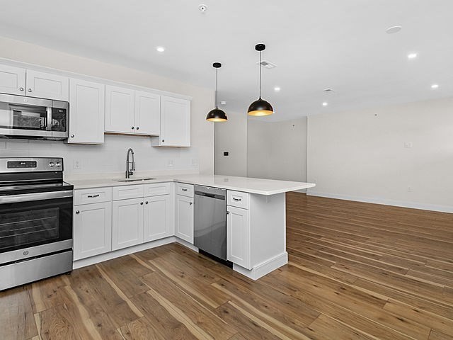 1 Pleasant Street, Unit 306 Cohasset, MA 02025 - Photo 3 of 23 a kitchen with a sink stainless steel appliances and cabinets
