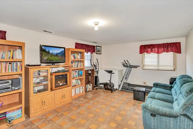 a living room with furniture a window and a book shelf