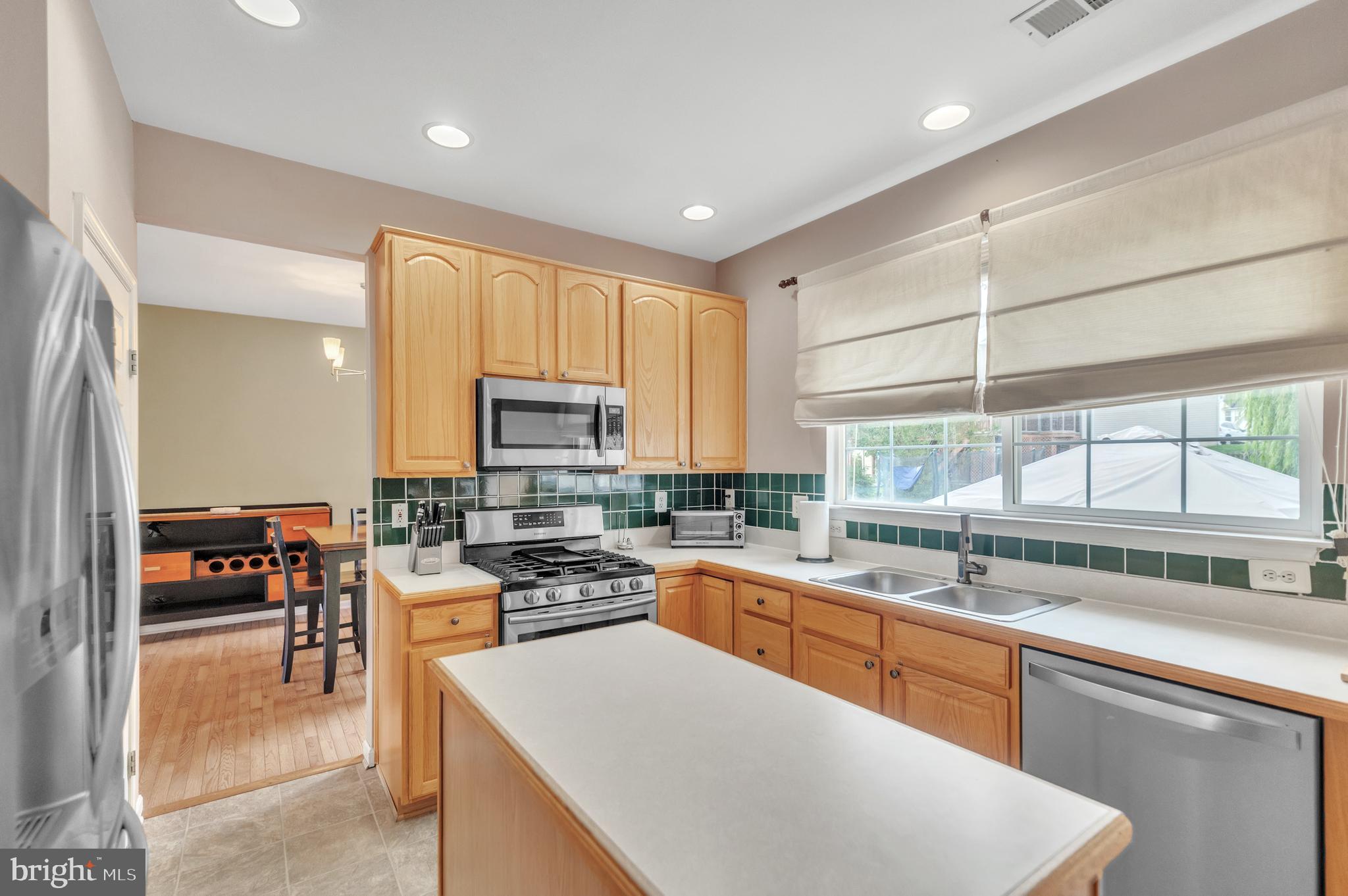 9879 Upper Mill Loop Bristow, VA 20136 - Photo 11 of 32 18x10 Kitchen w/ island & cer. tile backsplash