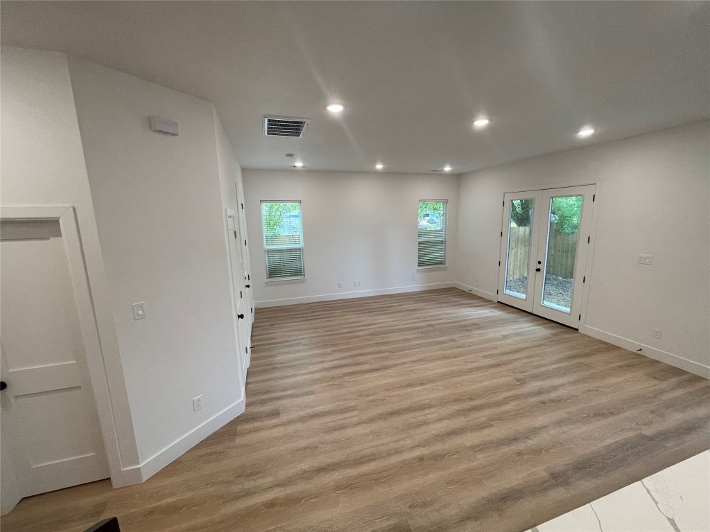 5312 Denmark Street Houston, TX 77028 - Photo 5 of 16 an empty room with wooden floor and windows