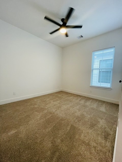 5312 Denmark Street Houston, TX 77028 - Photo 9 of 16 an empty room with a ceiling fan and window