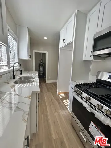 a kitchen with granite countertop a stove and a sink