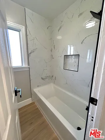 a white bath tub sitting next to a white sink and vanity