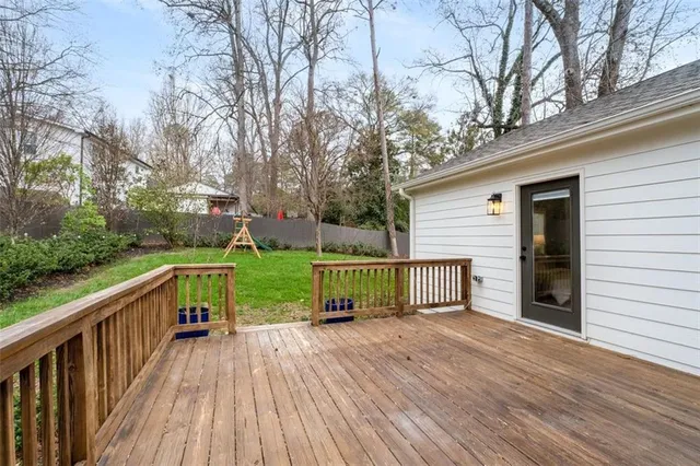 a view of house with backyard and deck