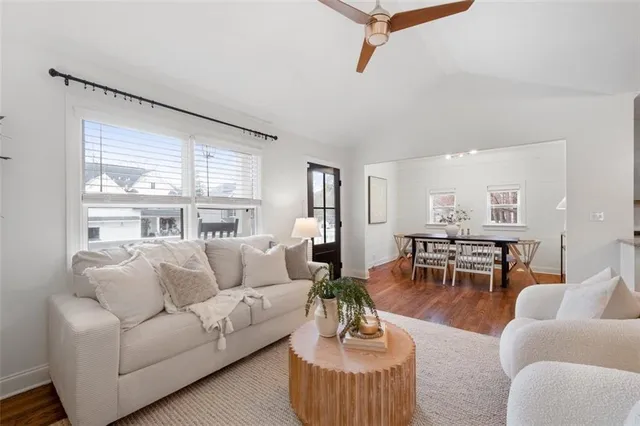 a living room with furniture wooden floor and a large window
