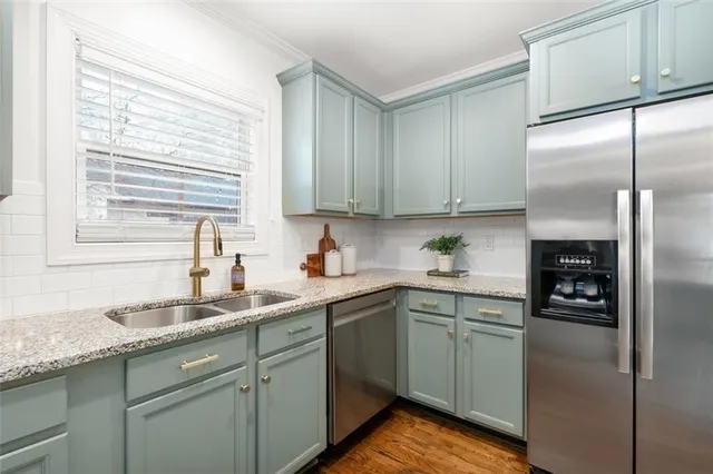 a kitchen with a sink cabinets stainless steel appliances and a window