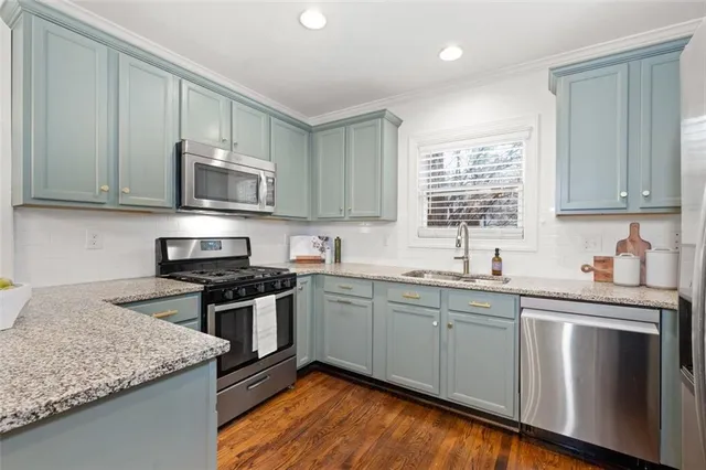 a kitchen with stainless steel appliances granite countertop a sink stove and refrigerator