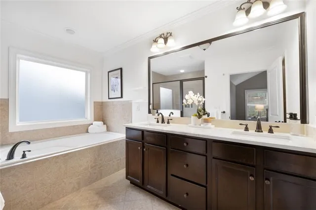 a bathroom with a bathtub double sink and mirror