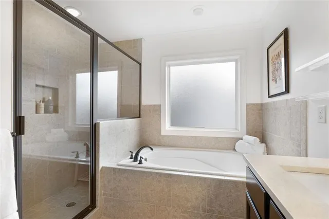 a bathroom with a tub sink and mirror