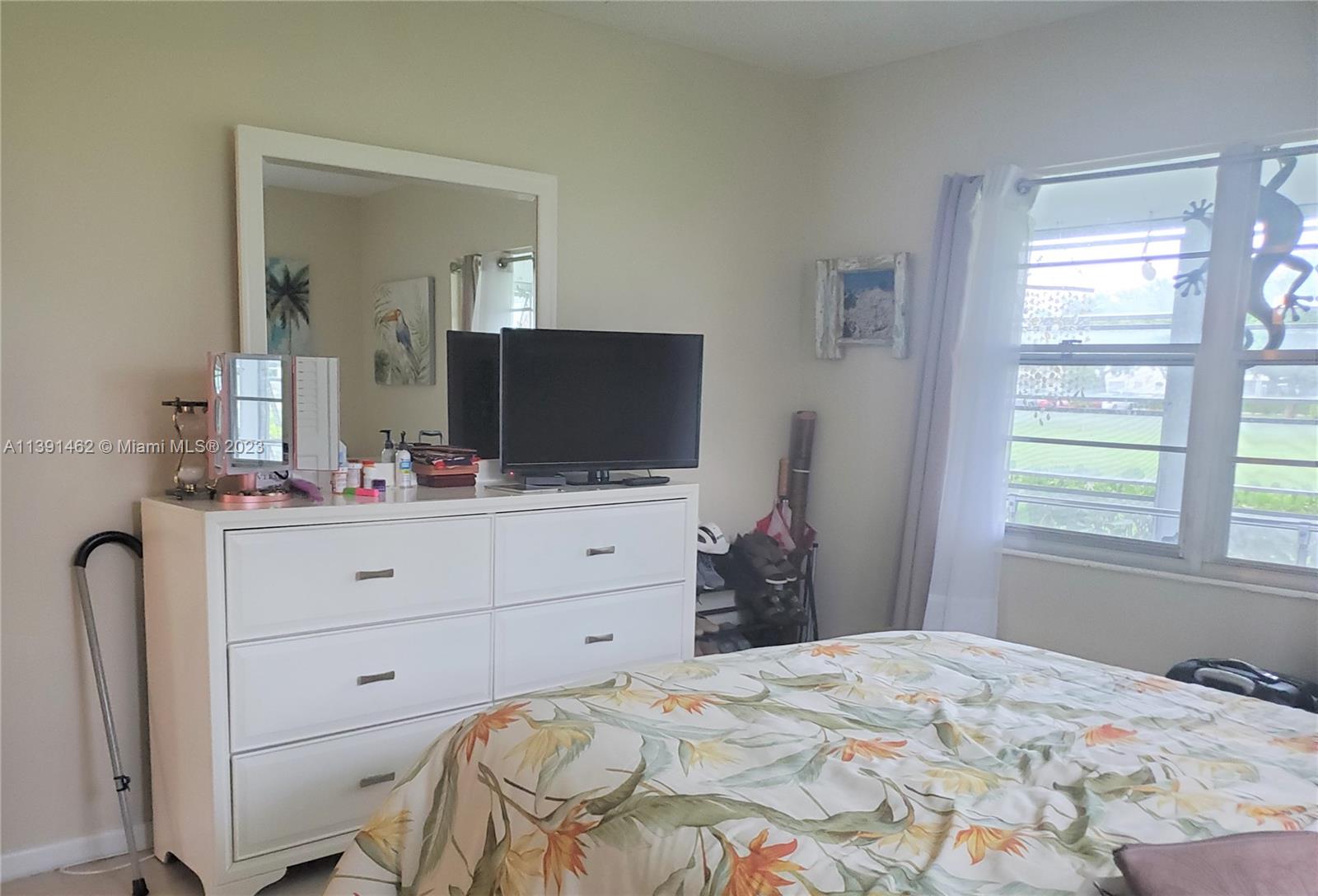 550 Mansfield M, Unit 550 Boca Raton, FL 33434 - Photo 6 of 14 a bedroom with a bed and flat screen tv