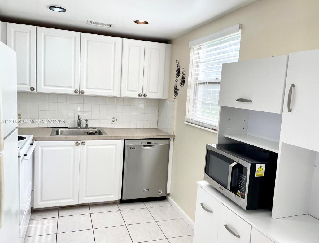 550 Mansfield M, Unit 550 Boca Raton, FL 33434 - Photo 8 of 14 a kitchen with granite countertop white cabinets and white appliances