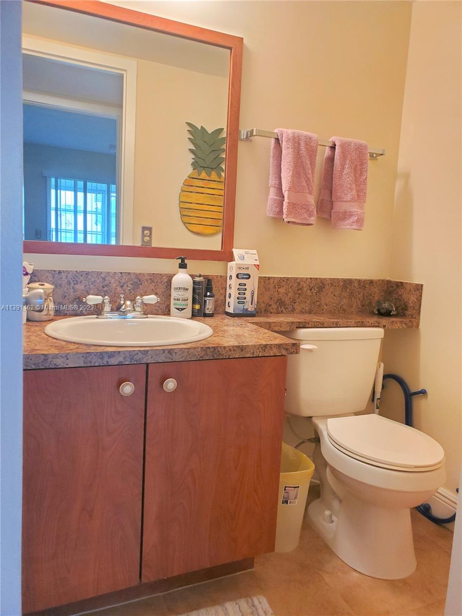 550 Mansfield M, Unit 550 Boca Raton, FL 33434 - Photo 9 of 14 a bathroom with a granite countertop toilet sink and mirror