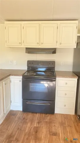a stove top oven sitting inside of a kitchen