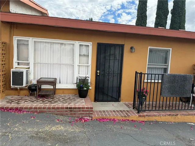 a backyard of a house with barbeque oven table and chairs