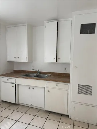 a kitchen with granite countertop white cabinets and sink