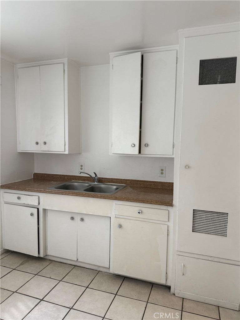 12102 Preston Street Grand Terrace, CA 92313 - Photo 7 of 20 a kitchen with granite countertop white cabinets and sink