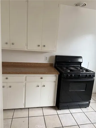 a kitchen with white cabinets and black appliances