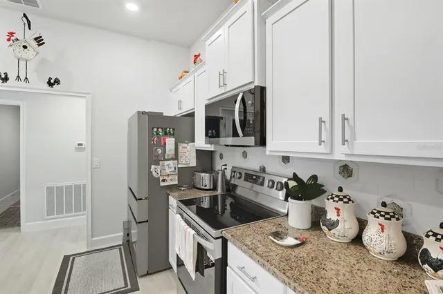 a kitchen with stainless steel appliances granite countertop a sink a stove and a refrigerator