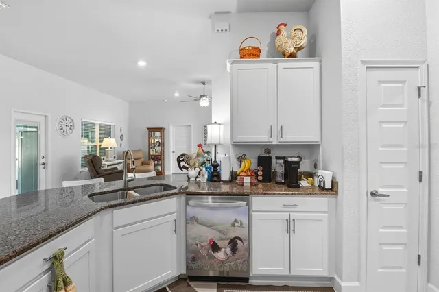 a kitchen with white cabinets and sink