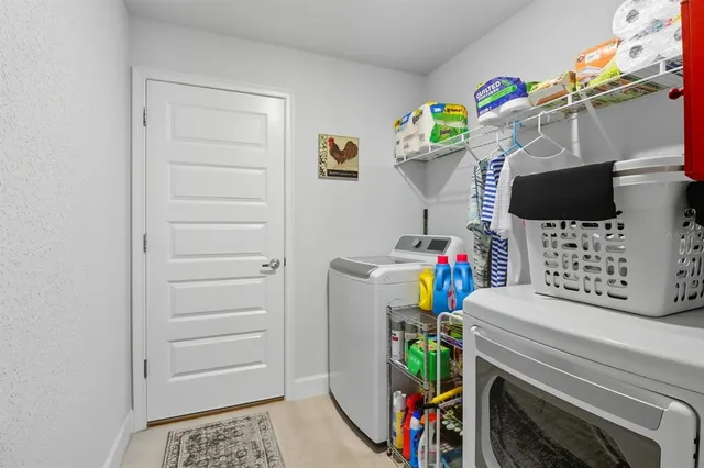 a view of a bedroom with fridge and workspace