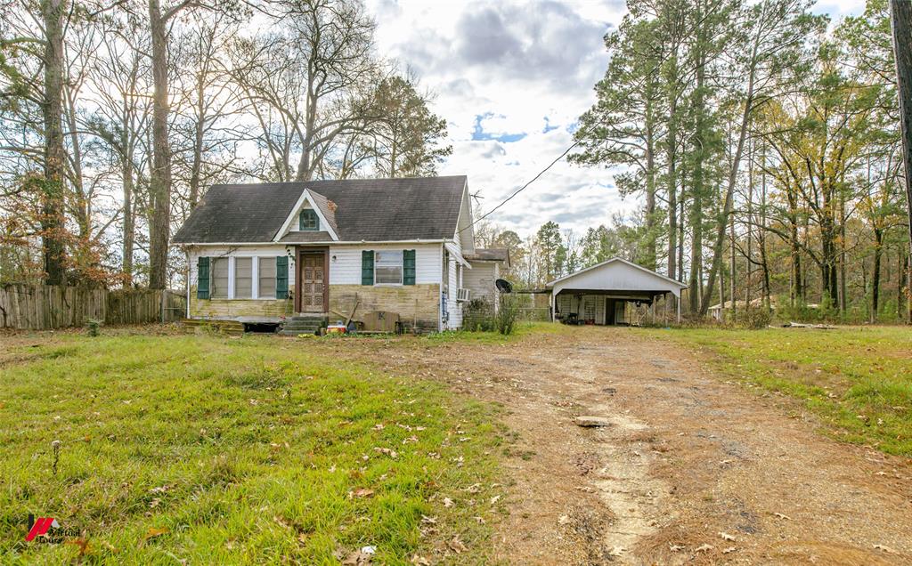 View of front of home featuring a carport and a front lawn