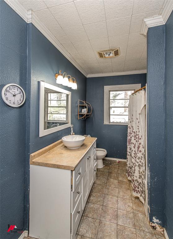 179 Daniel Thomas Road Springhill, LA 71075 - Photo 14 of 37 Full bath with visible vents, stone finish floor, ornamental molding, toilet, and vanity