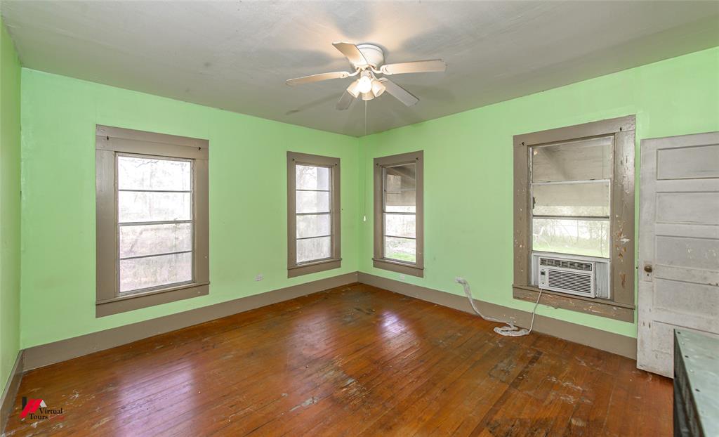 179 Daniel Thomas Road Springhill, LA 71075 - Photo 18 of 37 Unfurnished room featuring hardwood / wood-style floors, a ceiling fan, baseboards, and cooling unit