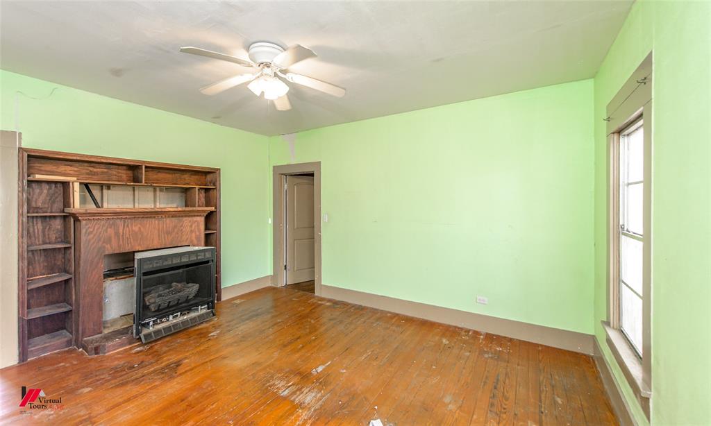 179 Daniel Thomas Road Springhill, LA 71075 - Photo 19 of 37 Unfurnished living room with hardwood / wood-style flooring, baseboards, a fireplace, and ceiling fan