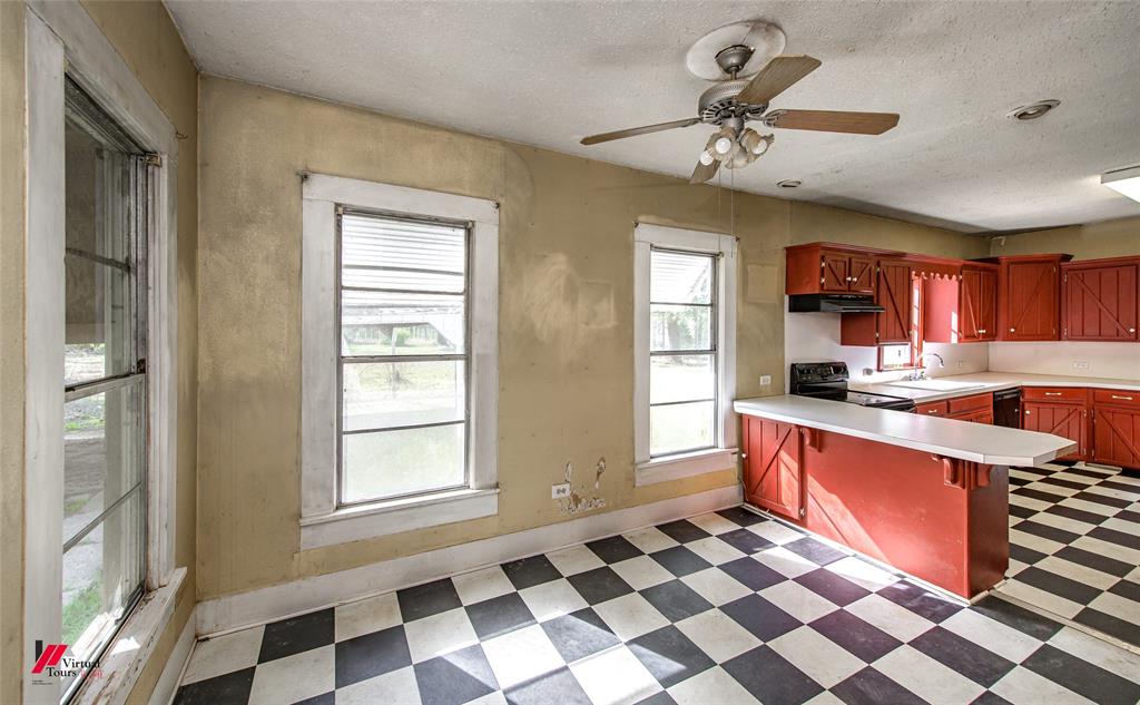 179 Daniel Thomas Road Springhill, LA 71075 - Photo 20 of 37 Kitchen with light countertops, under cabinet range hood, a peninsula, black appliances, and light floors