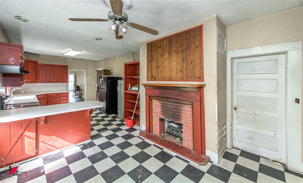 179 Daniel Thomas Road Springhill, LA 71075 - Photo 21 of 37 Kitchen with under cabinet range hood, ceiling fan, freestanding refrigerator, a fireplace, and light floors