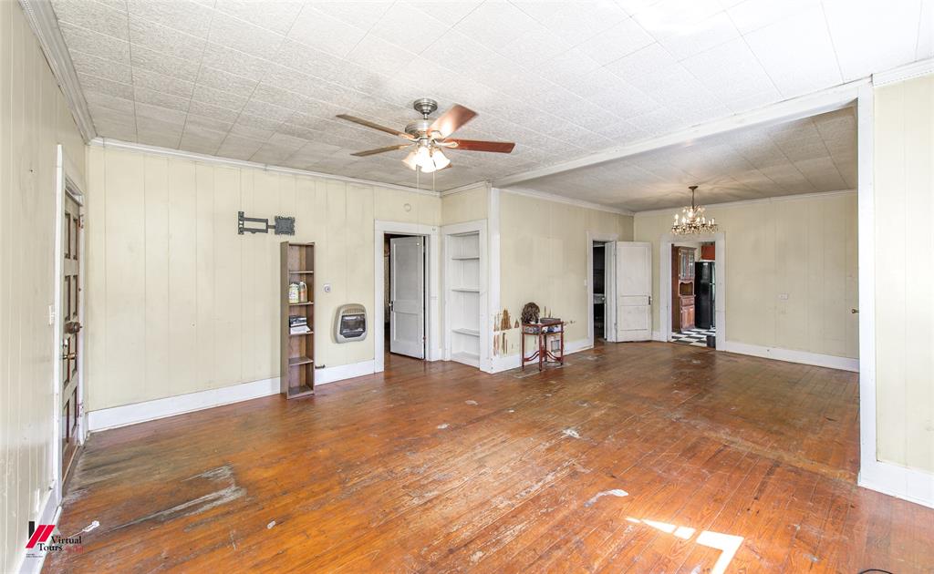 179 Daniel Thomas Road Springhill, LA 71075 - Photo 5 of 37 Unfurnished living room with heating unit, crown molding, ceiling fan with notable chandelier, and wood-type flooring