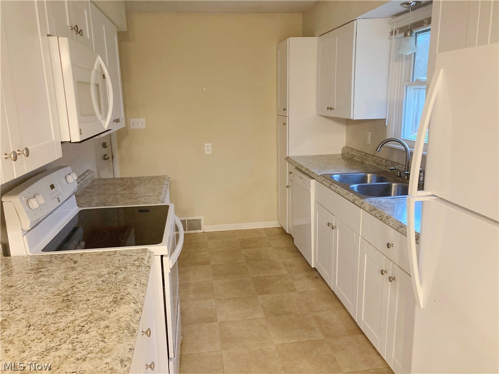 4953 Stevens Road Akron, OH 44319 - Photo 5 of 14 Kitchen with white cabinets, sink, white appliances, light flooring, and light stone countertops