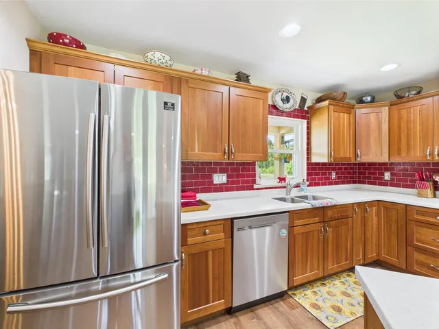 a view of a hallway with wooden floor and a living room