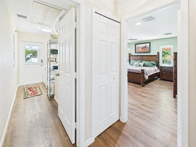 a spacious bedroom with a bed and dresser with wooden floor