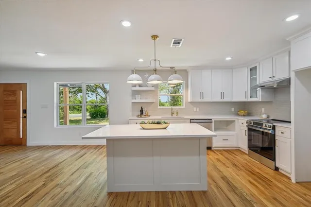 a kitchen with a stove a sink and a refrigerator