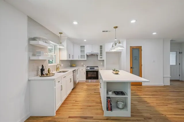 a kitchen with stainless steel appliances granite countertop a sink and cabinets