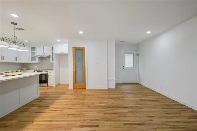 a view of a kitchen with kitchen island wooden floor appliances and window