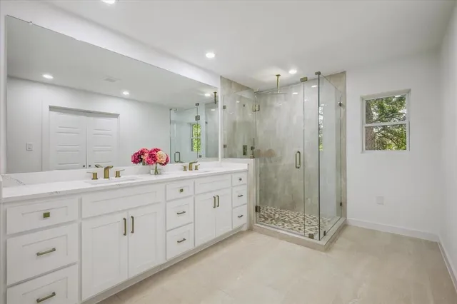 a bathroom with double vanity and a shower