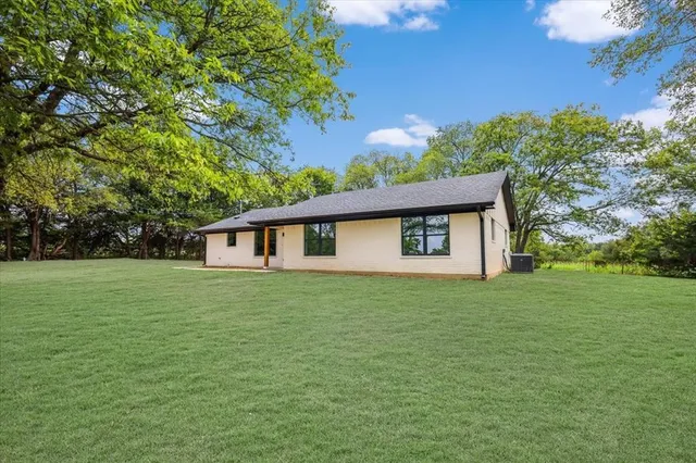 a house with huge green field in front of it