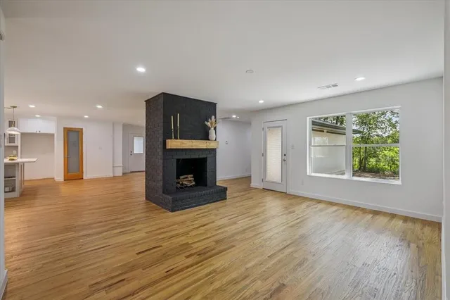 a view of empty room with wooden floor and fireplace
